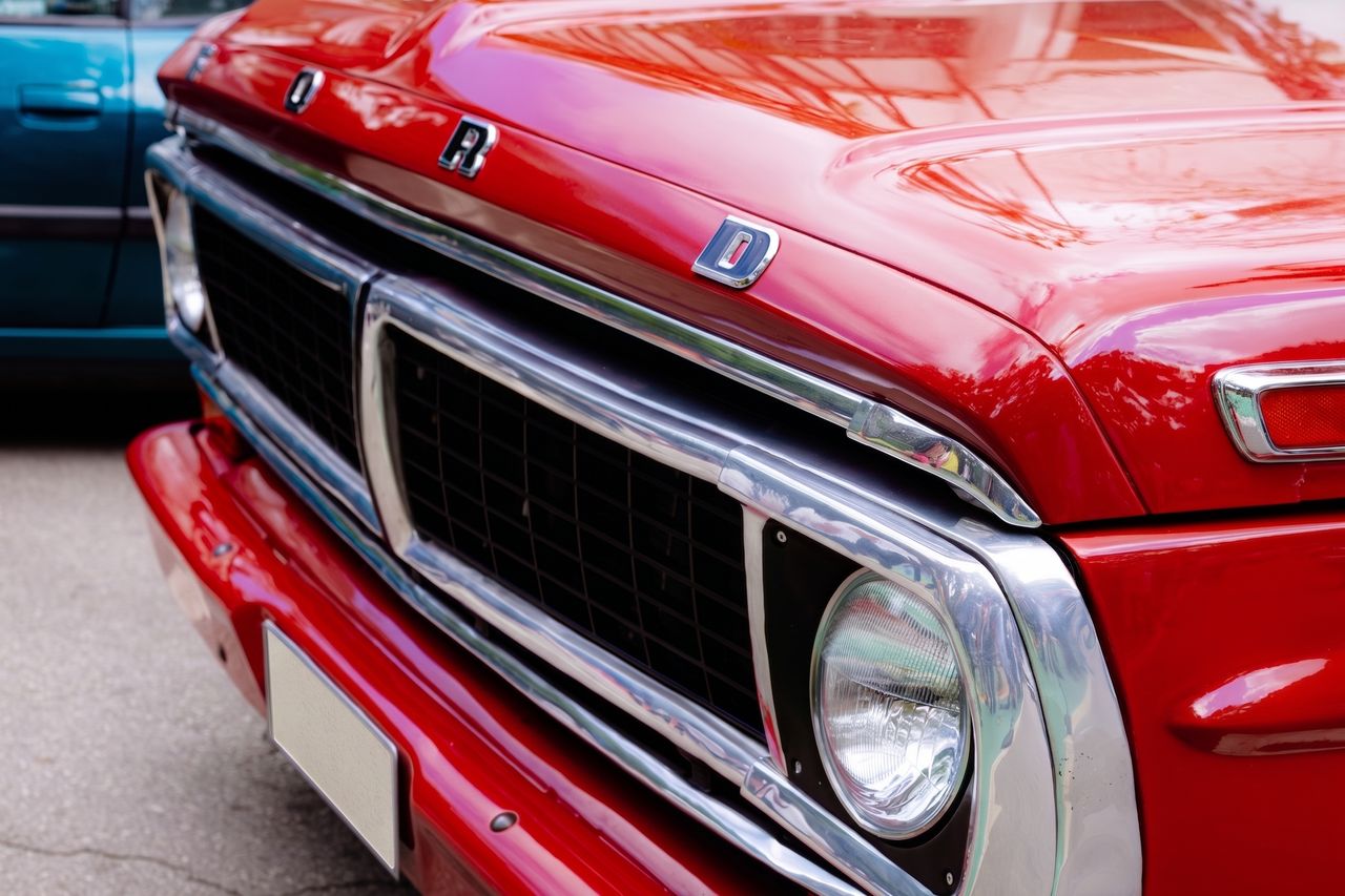 journey-01 A detailed view of the front grille and hood of a vintage red Ford truck in Belo Horizonte.